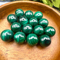 Green malachite spheres in a wooden bowl