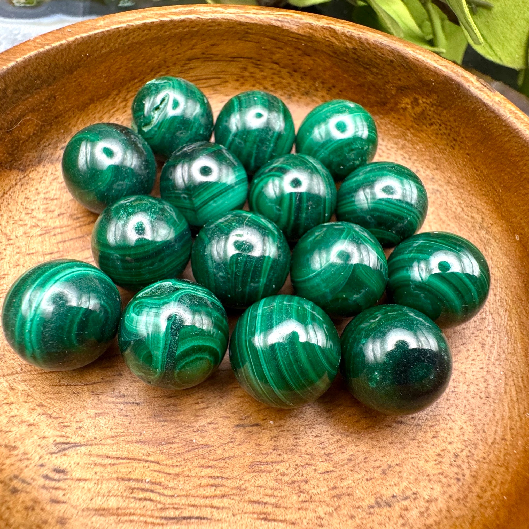 Green malachite spheres in a wooden bowl