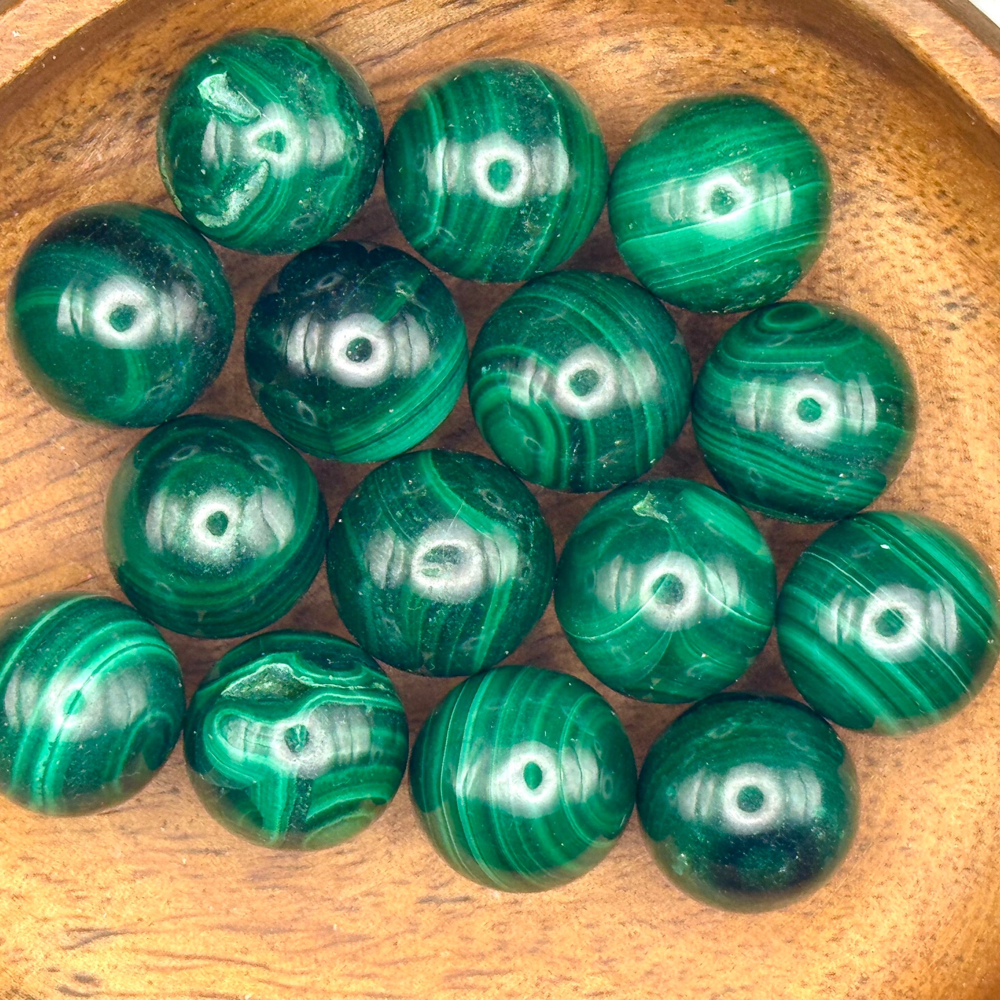 Green malachite spheres in a wooden bowl