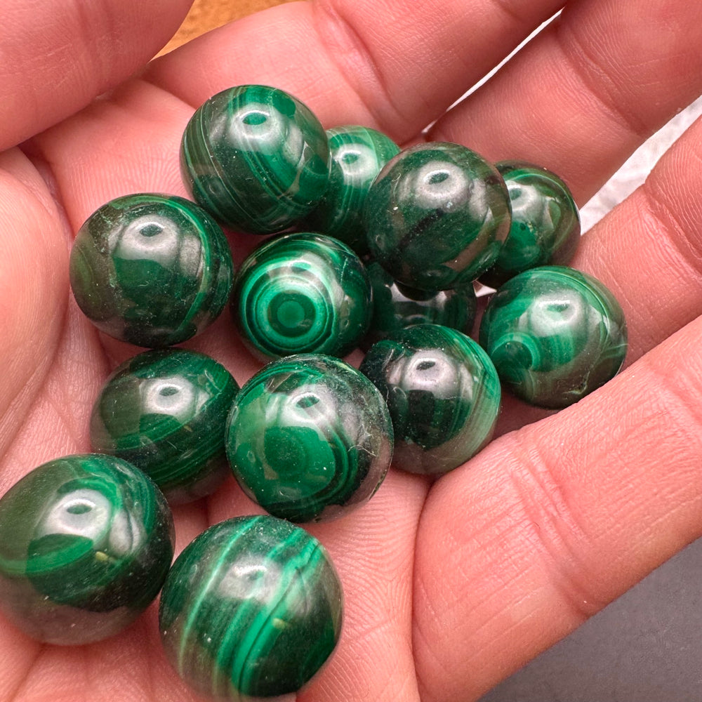 Green malachite sphere held in a hand