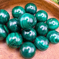 Green malachite spheres in a wooden bowl